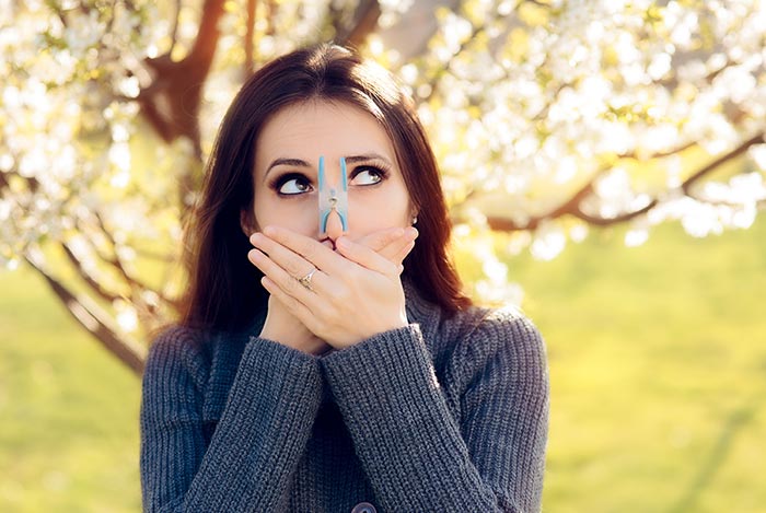 Kobieta z klamerką na nosie unikająca alergii